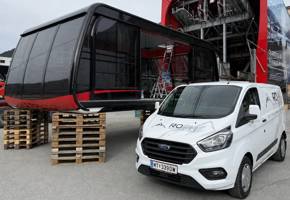 Kabine einer Seilbahn in der Werkstatt neben dem Servicefahrzeug von ROPH Montagen